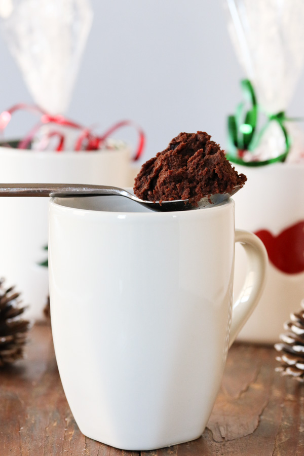 a spoonful of mug brownie perched on a white mug