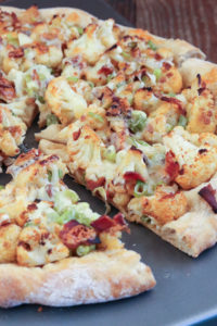 this cauliflower and bacon pizza is simple to assemble yet packed with flavor from roasted cauliflower, bacon, and cheddar cheese.