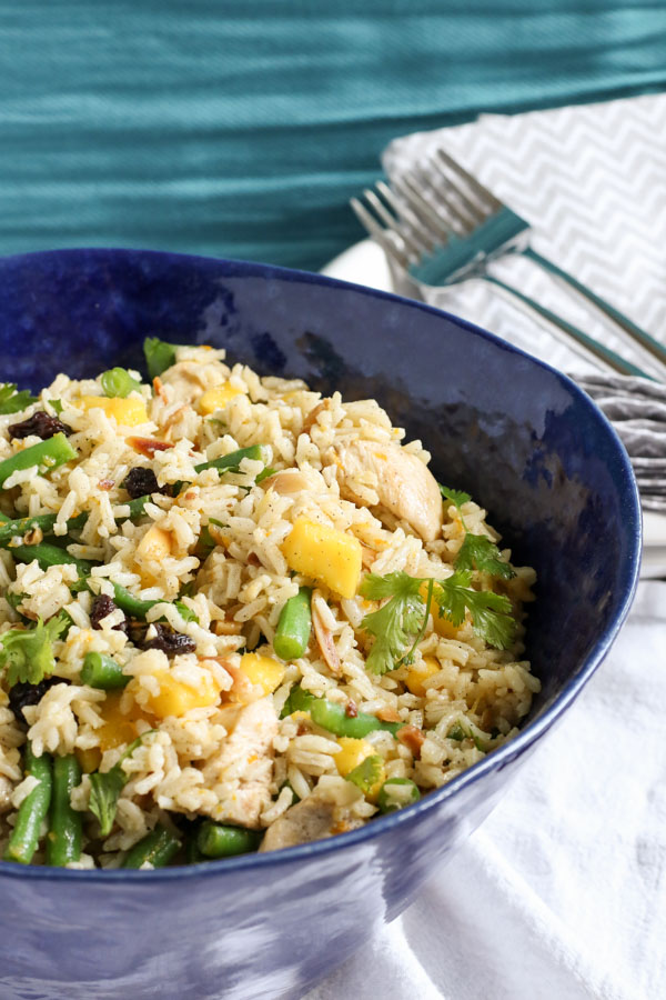 cardamom chicken and rice with mango and green beans is a perfect summer dinner all in one bowl. a zesty orange vinaigrette, raisins, and almonds add flavor and crunch. get this gluten free and dairy free recipe today!