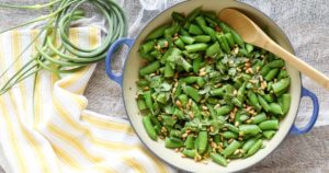 sugar snap peas with garlic scapes and basil include pine nuts and lemon zest for a delicious summer vegetable side dish. vegan/gluten free
