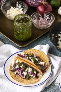 fish tacos with chimichurri sauce are delicious and quick and easy to prepare. cilantro, lime, garlic, and jalapeño flavor the bright sauce.