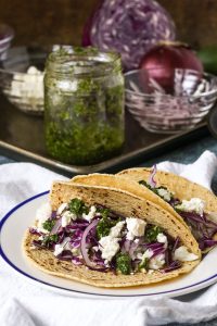 fish tacos with chimichurri sauce are delicious and quick and easy to prepare. cilantro, lime, garlic, and jalapeño flavor the bright sauce.