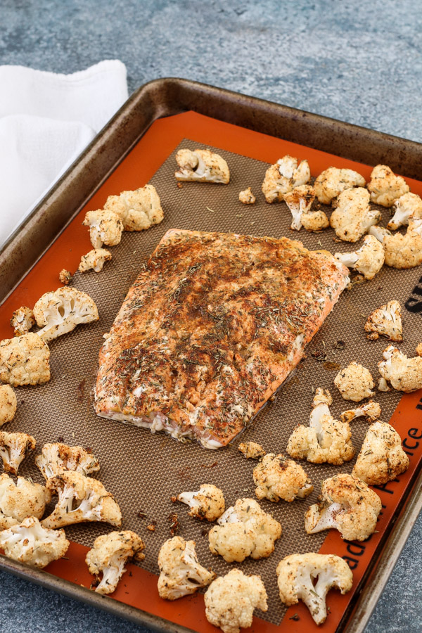 sheet pan salmon and cauliflower with spice rub is an easy weeknight dinner that comes together in 35 minutes with just 7 ingredients. mustard and just 3 pantry spices provide tons of flavor in this healthy recipe. get the recipe now for dinner tonight!