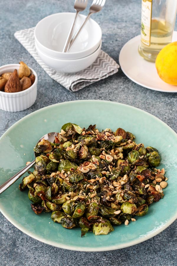 roasted brussels sprouts with bacon and figs on a teal plate