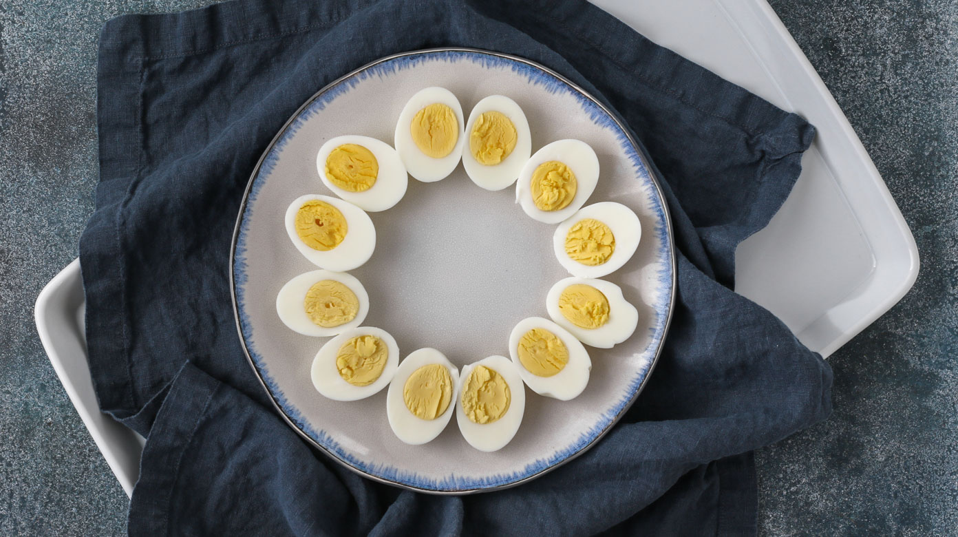 easy peel hard boiled eggs sliced in half on a serving plate