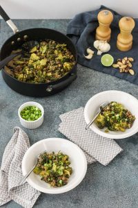 spicy sesame beef and broccoli in white bowls